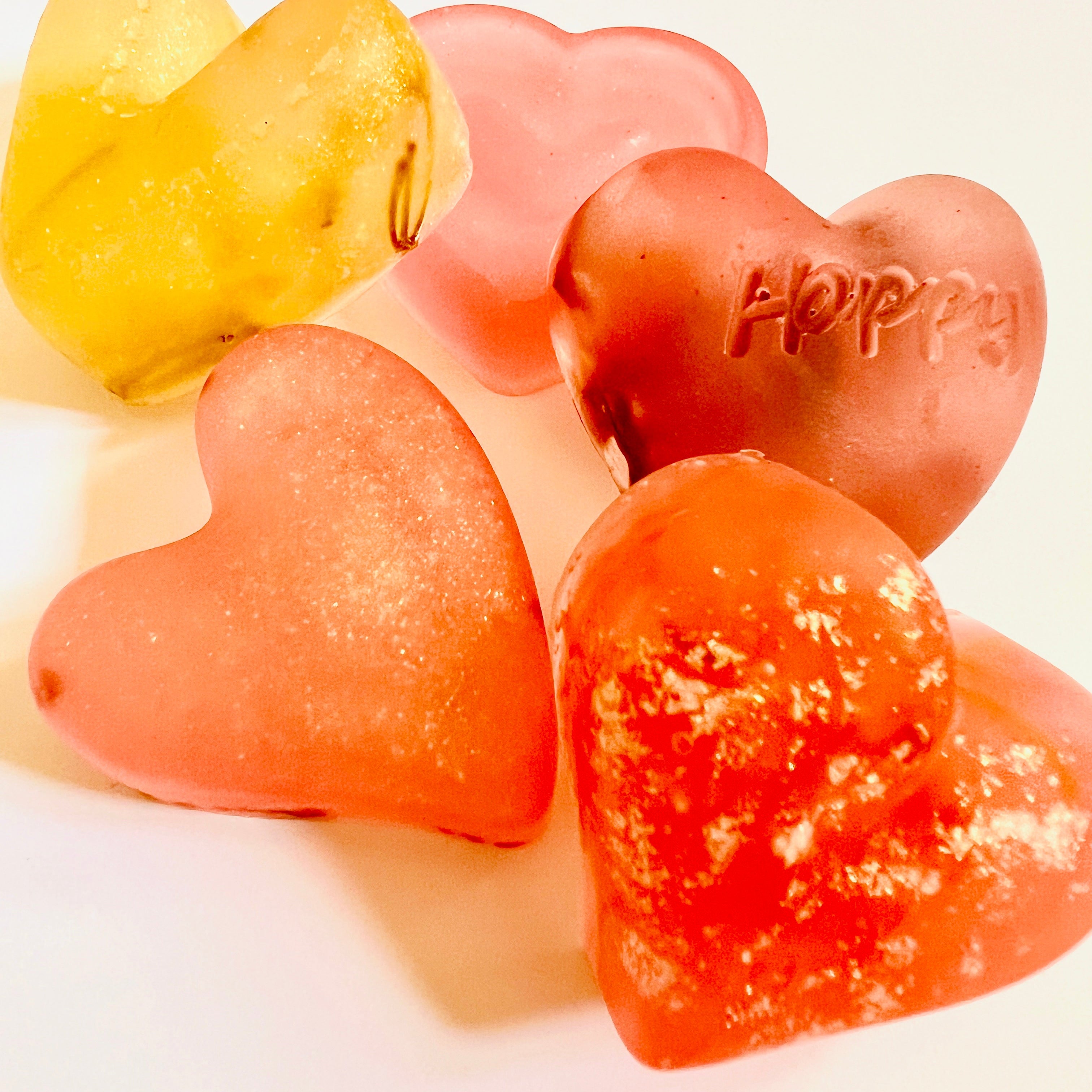Heart-shaped soaps in various colors on a light background